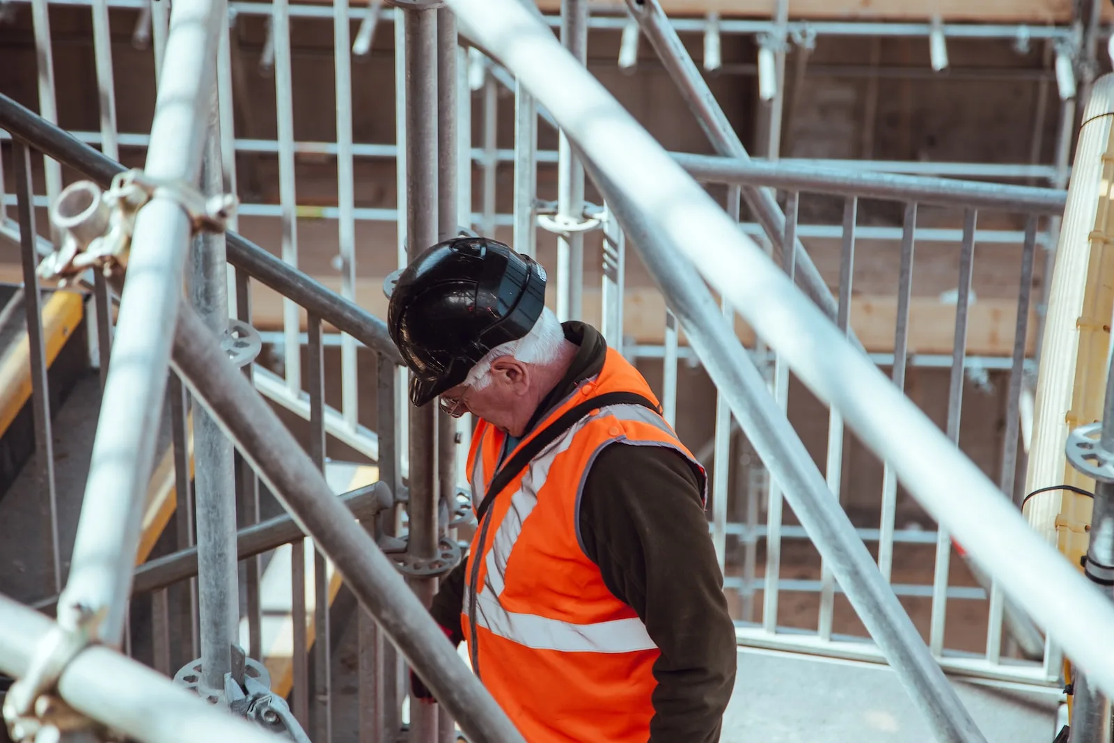Photo by Clem Onojeghuo man standing under scaffoldings